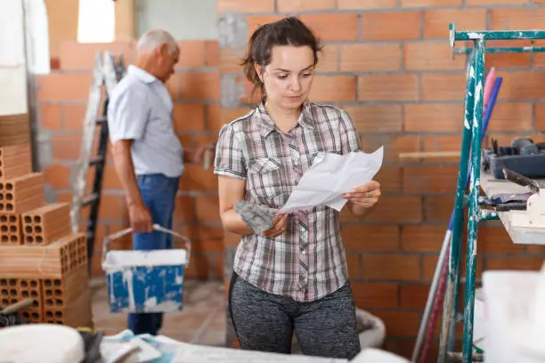 Homeowner comparing detailed bathroom remodel estimates on paper