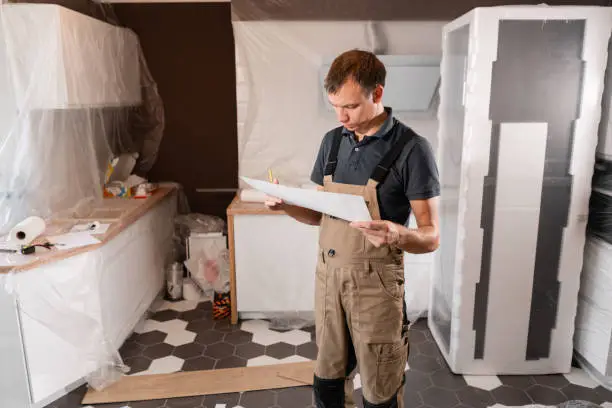 Experienced bathroom remodel contractor reviewing renovation blueprints