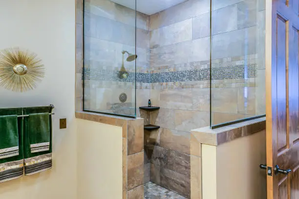 Stylish walk-in shower with glass doors and tile accents