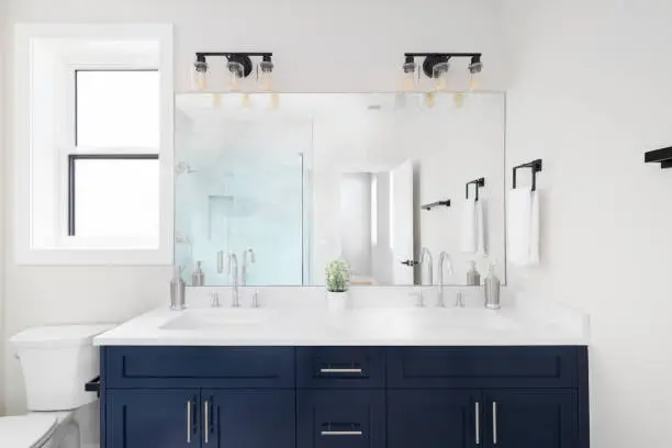 Bathroom renovation featuring vanity lighting with task lights on both sides of the mirror.