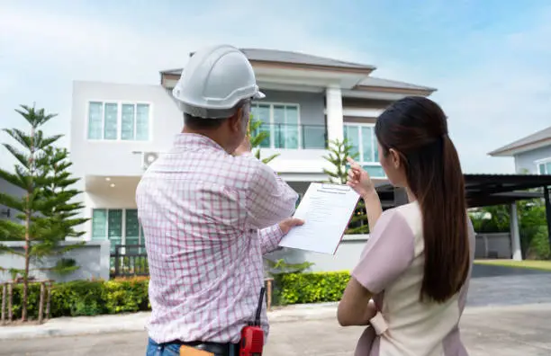 Contractor reviewing permit plans with homeowner