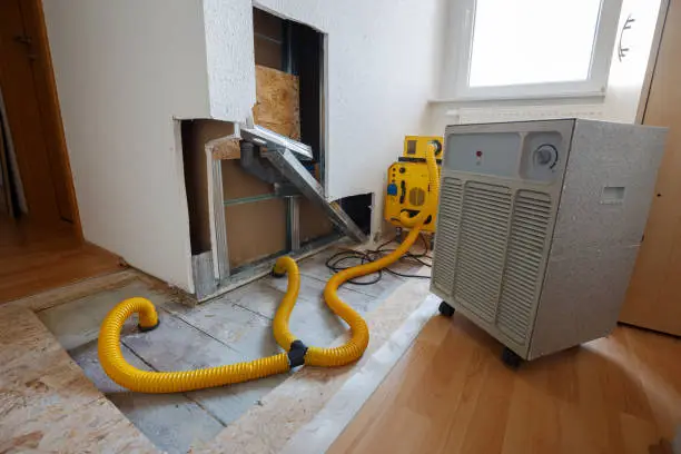 Technician using water extraction equipment during home restoration