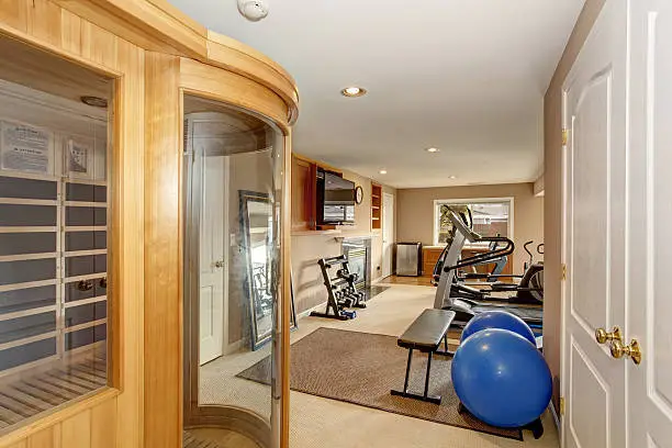 Finished basement living space with home gym equipment – basement remodeling