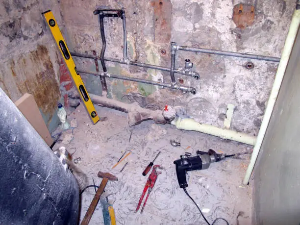 failed DIY bathroom remodel with exposed plumbing and tools