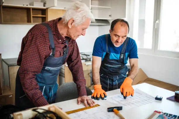 Kitchen and bathroom remodel contractors reviewing safety-compliant plans for resilience upgrades