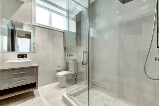 Modern bathroom with mold-resistant tiles, glass shower doors, and smart ventilation to prevent humidity buildup.