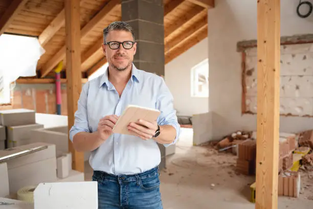 Remodeling contractor reviewing attic floor plans – attic remodeling planning
