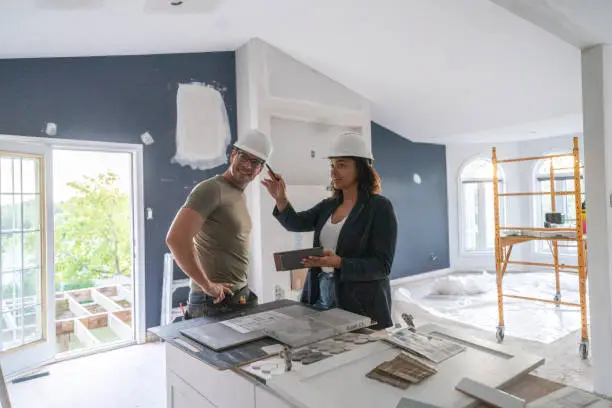 Remodel contractor planning disaster-resistant kitchen and bathroom features with homeowners