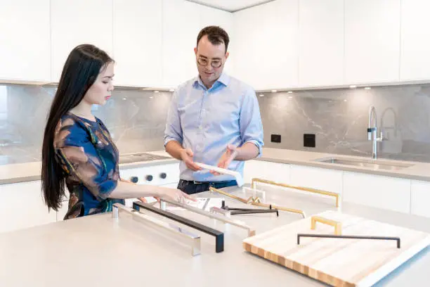 Kitchen remodel consultation with designer reviewing plans and samples