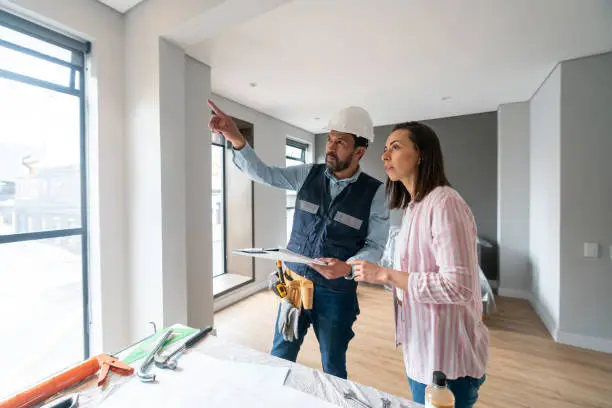 Contractor and homeowner discussing kitchen remodel lighting layout