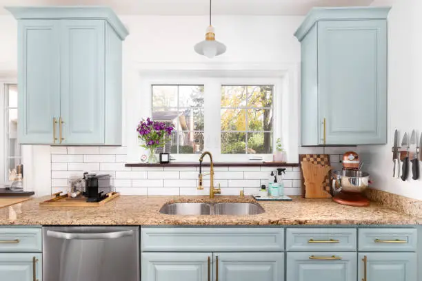 Stylish budget kitchen remodel with painted cabinets and modern lighting fixtures.