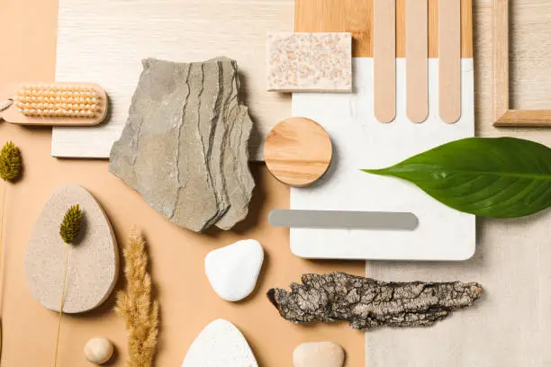 A serene kitchen and bathroom mood board displaying natural textures, wood samples, stone tiles, and greenery, illustrating biophilic design inspiration.