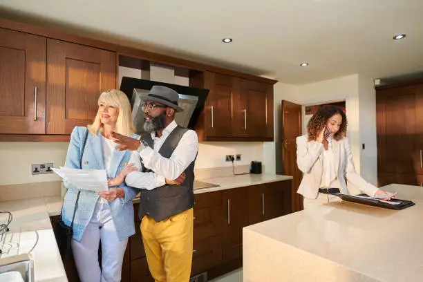 Homebuyers touring a property and examining the kitchen and bathroom closely.