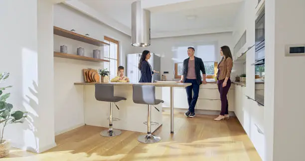 A family enjoying a peaceful kitchen space designed with noise-reducing materials like padded floors and soft finishes.