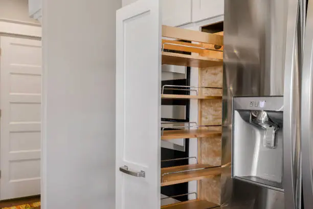 Pull-out pantry and built-in kitchen storage inside modern remodeled kitchen