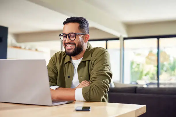 A person using a laptop or smartphone to search online for kitchen remodel services.