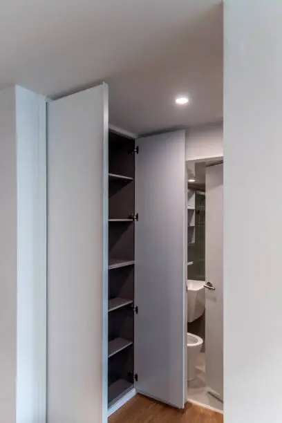 Fold-away fixtures, hidden cabinets, and sliding doors inside a small but organized bathroom.