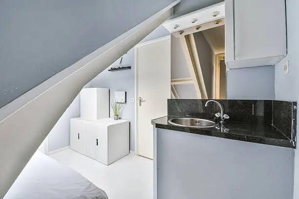 Compact bathroom and kitchenette built into an attic conversion – attic home remodeling features