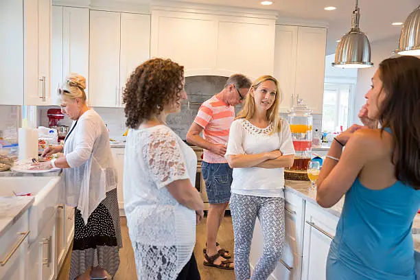 People gathered in an open kitchen during a home party remodel