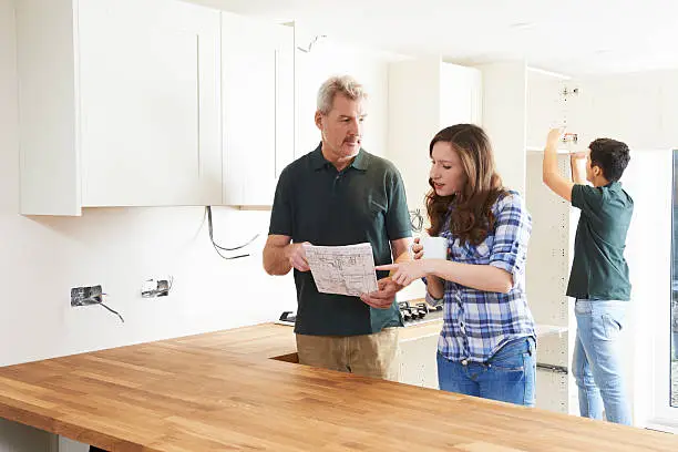 Kitchen remodel contractor reviewing entertaining-focused layout with client