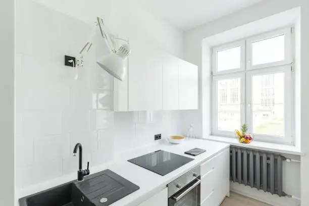small kitchen remodel with white tones and glossy backsplash