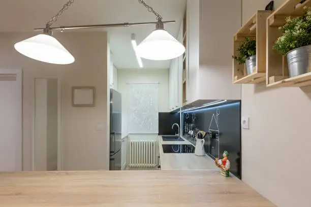 Small kitchen remodel with space-saving designs like fold-out counters and open shelving.