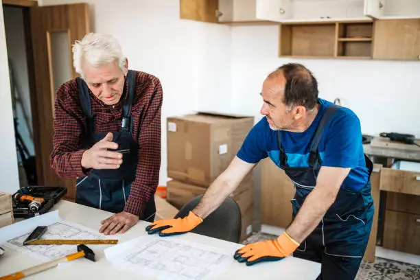 Remodel contractors discussing soundproofing plans, showcasing KBR’s expertise in kitchen and bathroom remodels.