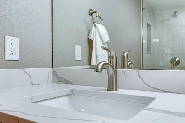 Bathroom with left-sided faucet and mirror, highlighting KBR’s kitchen and bathroom remodeling for left-handed usability.
