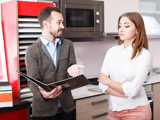 Contractor discussing dietary-focused kitchen plans in showroom.