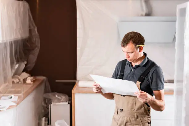 Contractor reviewing energy-efficient kitchen plans in showroom.