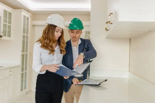Contractor reviewing plans with a client in a showroom.