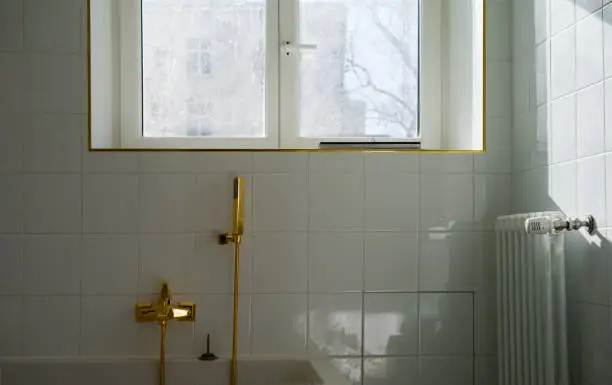 Bathroom with porcelain tiles and brass fixtures on a budget.
