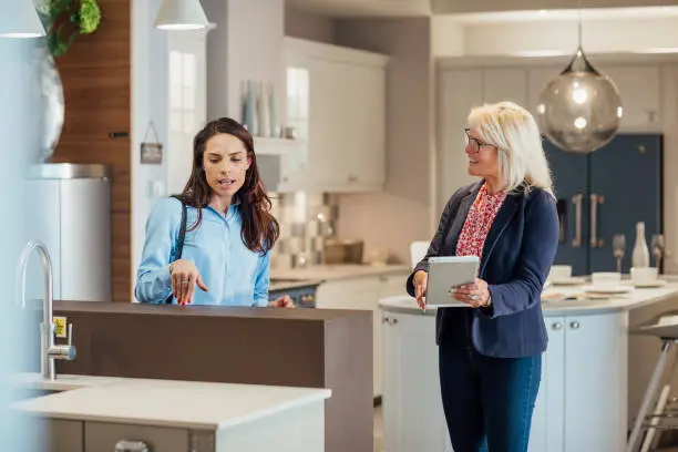 KBR project manager discussing a timeline with a homeowner in a showroom.