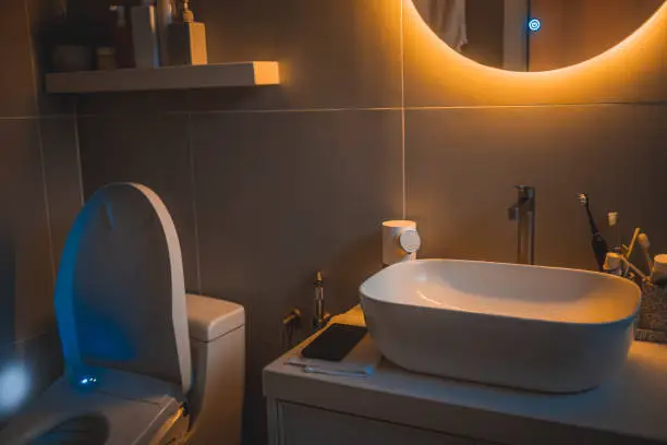 Bathroom with voice-activated lighting and motion-sensor faucet.