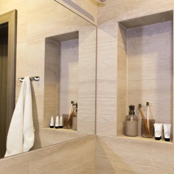 Bathroom with hidden storage behind mirror and recessed niches.