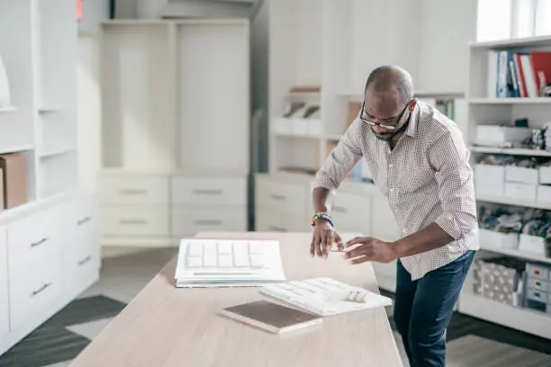 Contractor reviewing 3D-printed kitchen component plans in showroom.