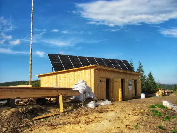 Off-grid bathroom remodel in progress with solar panels and rainwater system.