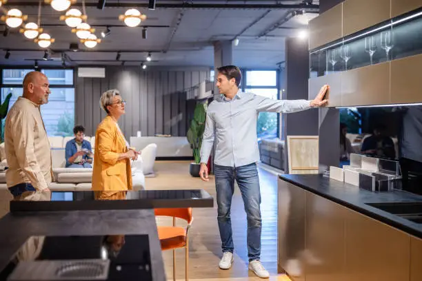 KBR contractor discussing a 3D accessible kitchen design with a client in a showroom.