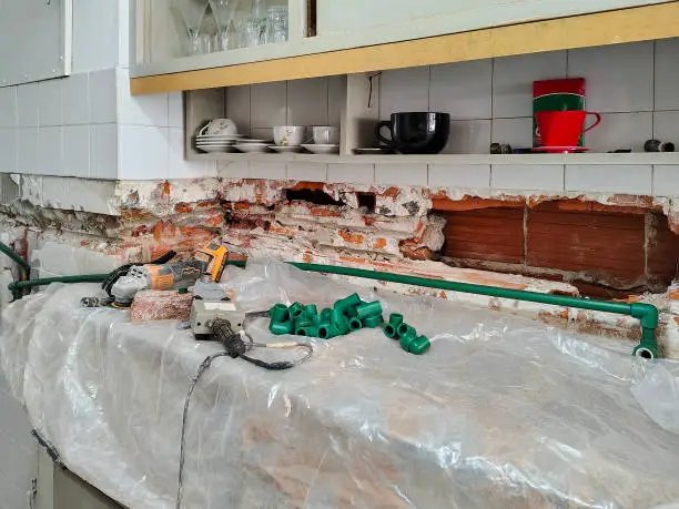 Kitchen with exposed plumbing, highlighting hidden cost issues.