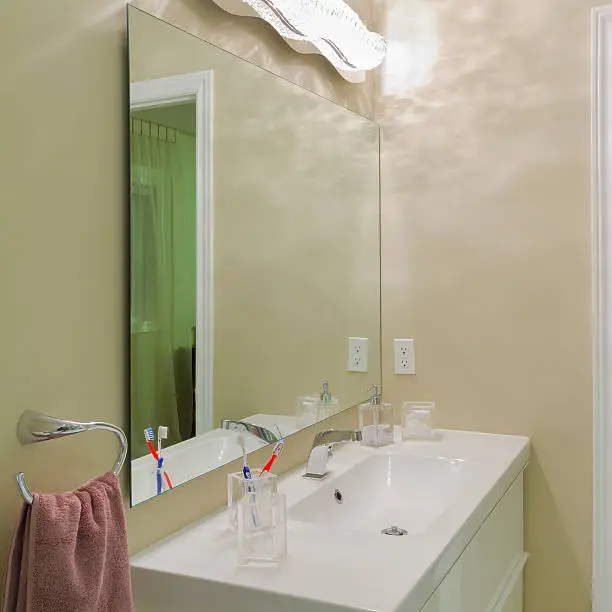 Bathroom with updated vanity and frameless mirror.