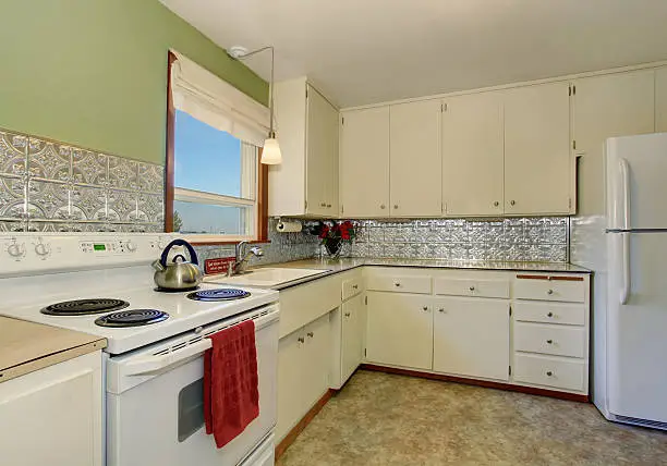 Refaced cabinets and affordable tiles in a small kitchen remodel.