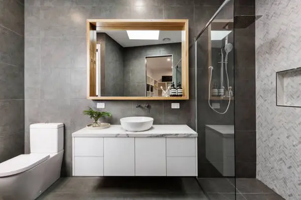 Bathroom with glass shower and frameless mirror.