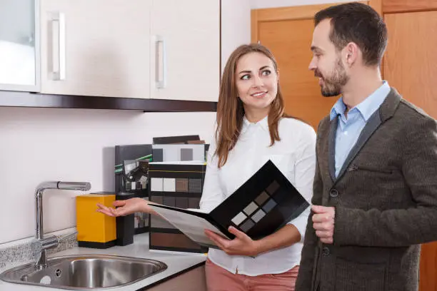 Contractor discussing luxury kitchen plans in showroom.