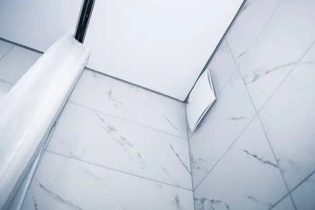 Bathroom with waterproof tiles and smart ventilation system.