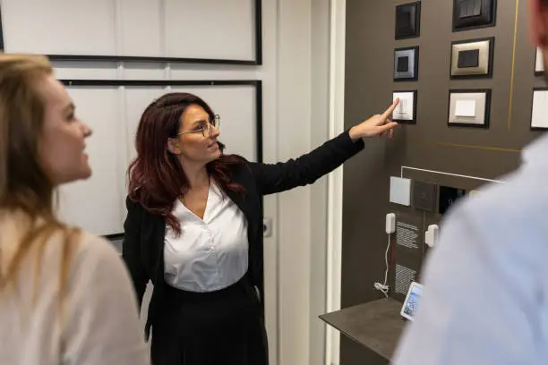 Contractor showcasing smart lighting controls in a showroom.