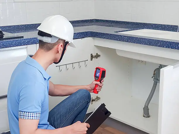 Contractor showcasing smart leak detection devices in a showroom.