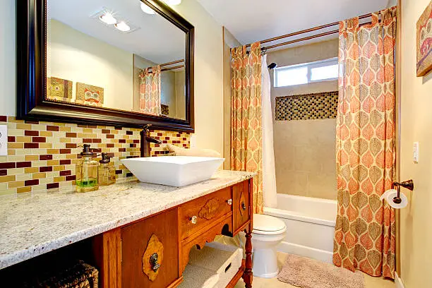 Bathroom with an antique dresser vanity and salvaged tile backsplash.