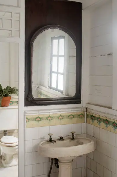 Bathroom with salvaged tiles and repurposed mirror frames.