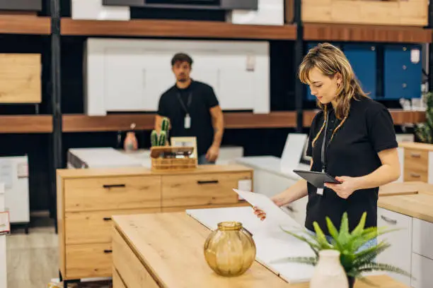 KBR contractor reviewing sustainable remodel plans in a showroom.