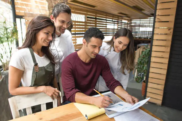 design team looking at outdoor kitchen plans with samples and client